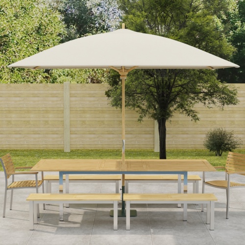 70440 Vogue 7 piece Teak and Stainless Steel Picnic Set with optional umbrella in side view in front of a pool with landscape plants and trees in the background