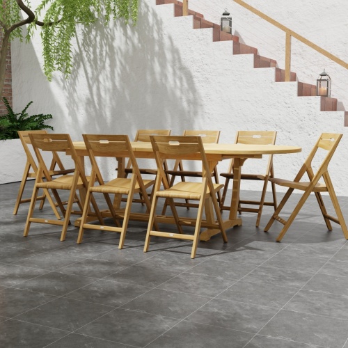 70516 Montserrat Surf 9 pc Dining Set of Monserrat Oval Dining Table and 8 Surf Folding Chairs end angled view with landscaping plants and staircase in background 