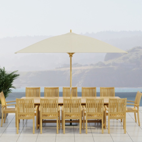 70757 Sussex Veranda 13 pc Teak Dining Set with optional umbrella in side view on patio with ocean and land views in background