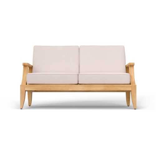 13121DP laguna teak loveseat with cushions and 2 ottomans front angle on patio with privacy wall in the background