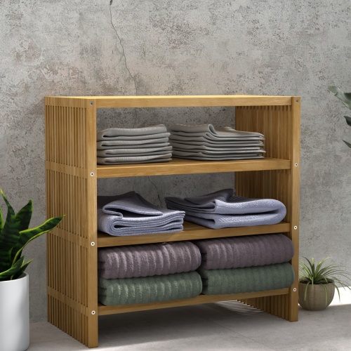 18220 Teak Storage Shelf with towels folded on the 3 shelves in angled front view next to 3 potted plants against a wall