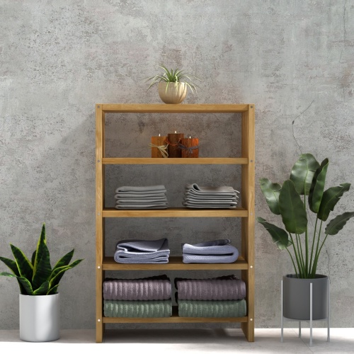 18221 Teak 48 inch Storage Shelf in front view between 2 potted plants against a wall with a potted plant on top of shelf and set of candles and folded towels on the 3 lower shelves