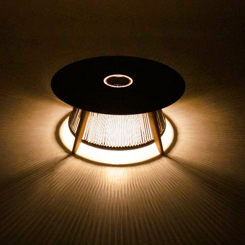 14105 Luna Round Coffee table with light reflecting from bottom angled on patio