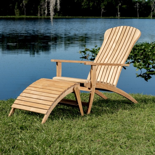 70000 Adirondack Chair and Footrest in angled side view on green grass with lake background