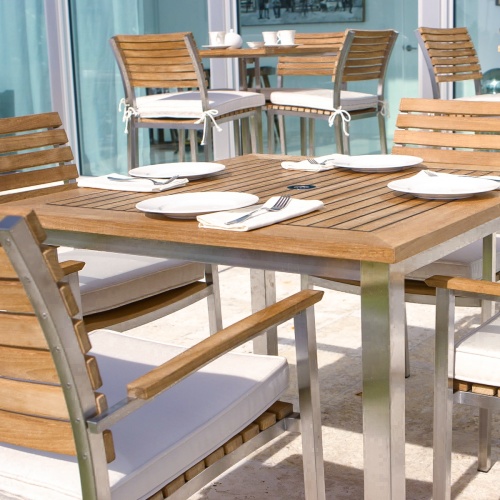 70014 Vogue teak and stainless steel 5 piece Dining Set closeup view with place settings 2 coffee cups and glass sliding doors in background