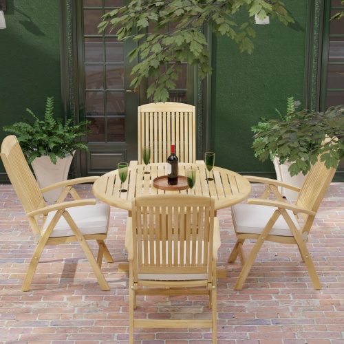 70028 Barbuda Reclining 5 pc Teak Set in angled top view with optional seat cushions and umbrella on brick patio with house and landscaping plants in background