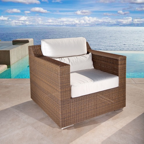 70259 malaga wicker lounge chair with cushions angled on patio with pool ocean and blue sky in background