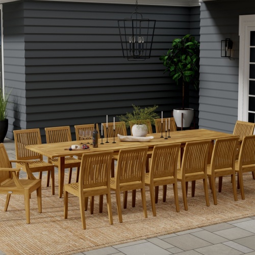 70809 Grand Laguna 15 pc Teak Dining Set with vase and candles and glasses on patio with potted plant and door of house in the background