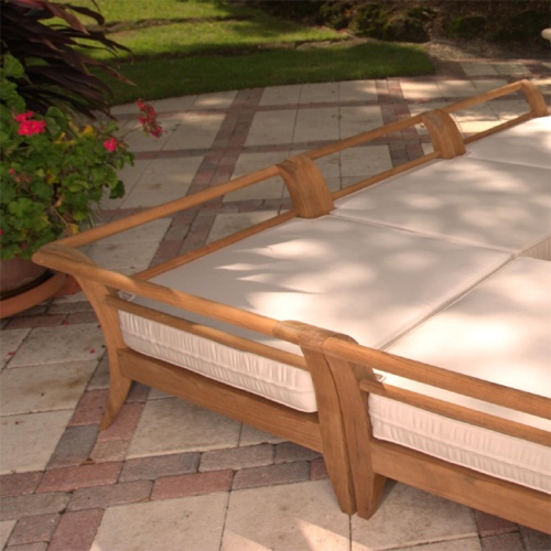 72375MTO Aman Dais Corner Seat Cushion on Aman Dais Teak Corner Frame on paver patio with landscape plants and grass in background