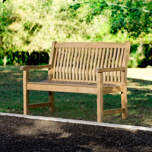 13218 Veranda Teak 4 foot Bench on grass field with garden in front and trees in background