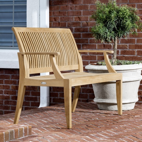 13811 Laguna 5 foot Teak Bench side angled view on brick patio with white potted tree and front of house in background
