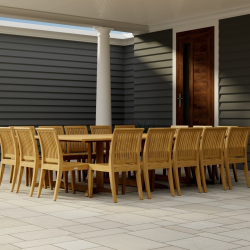 70288 Pyramid Teak Dining Set for 16  in corner view on covered patio with house and wood door in the background