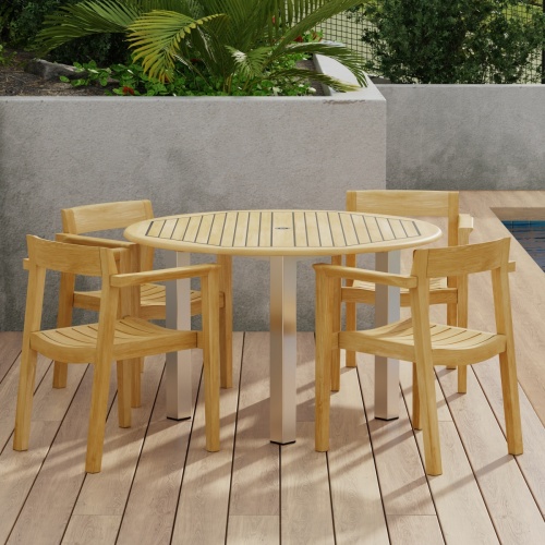 70478 Vogue Horizon Dining Set of 4 Horizon Dining Armchairs and Vogue 48 inch Round Teak and Stainless Steel Dining Table on patio with privacy wall lined with plants next to pool 