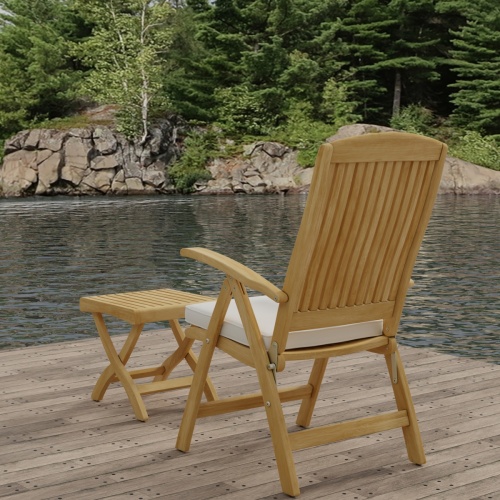 70706 Barbuda Teak Recliner & Ottoman Side Table Set showing Barbuda Recliner Teak Armchair with Optional Seat Cushion in back view on dock with lake and trees in background 