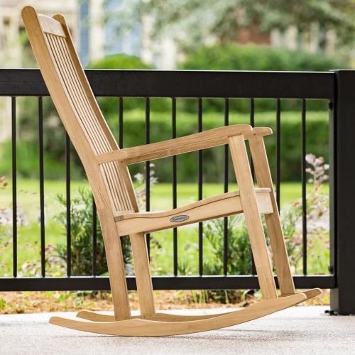 12223 veranda teak rocking chair on porch side view with railing and landscaped lawn in background