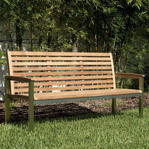 23200 Vogue 5 foot Teak and Stainless Steel Bench angled view on grass with shrubs in background