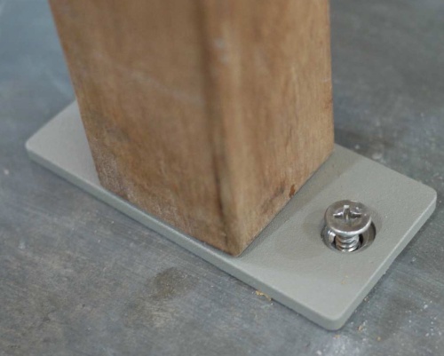 40010 Westminster Bench Anchor Bracket attached to Outdoor Teakwood Bench bottom leg showing bracket attached to concrete floor 