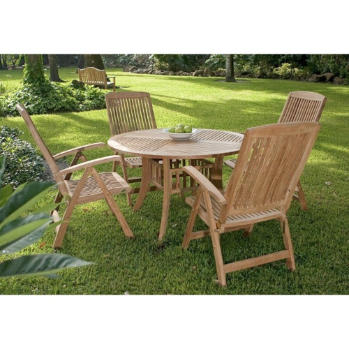 70045 Hyatt Recliner 5 piece round teak Dining Set on a grass lawn with white bowl of green apples on table and trees and shrubs in background