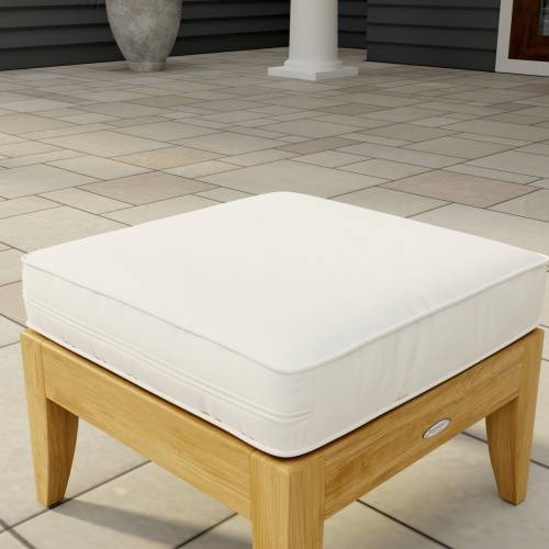72324MTO Laguna Ottoman Cushion with Quick Dry Foam Core showing angled corner view on the Laguna Ottoman Teak Frame on tiled patio with partial view of house in background