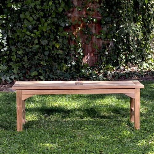 13940 Veranda 4 foot Teak Backless Bench side view on grass area with trees & shrubs in background