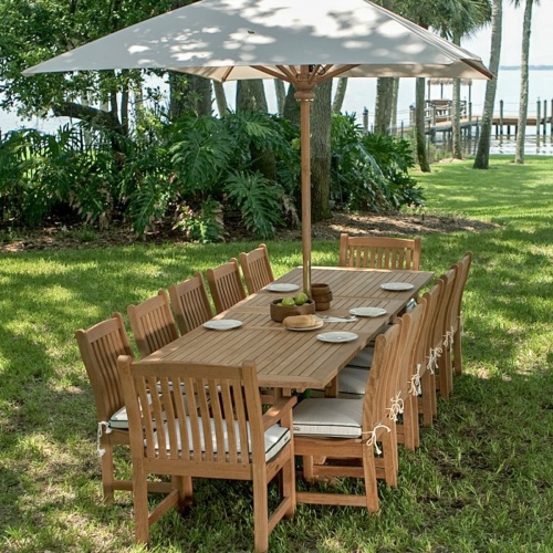 17640F Grand 10 feet Rectangular teak Umbrella in dining set on grass with apples bread plates and bowls on top with trees dock and water view in background