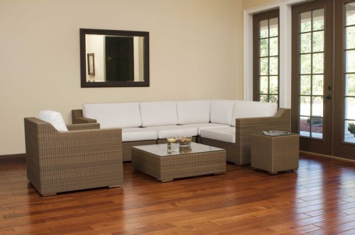 31004 malaga synthetic wicker collection indoor angle view on wood floors wall mirror behind sofa bowl and floating candle on table with french doors overlooking patio