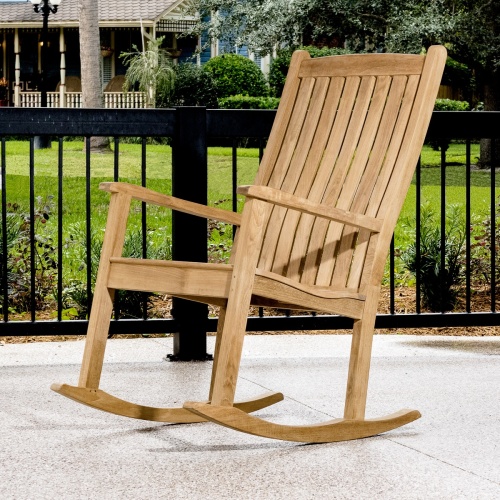 12223 Veranda Teak Rocking Chair on porch in side view with railing and landscaped lawn in background