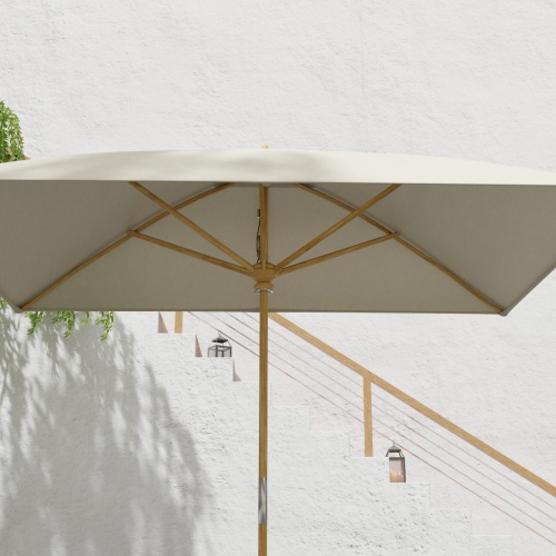 17640F Grand 10 feet Rectangular teak Umbrella with white canvas canopy extended in angled side view with staircase in the background 