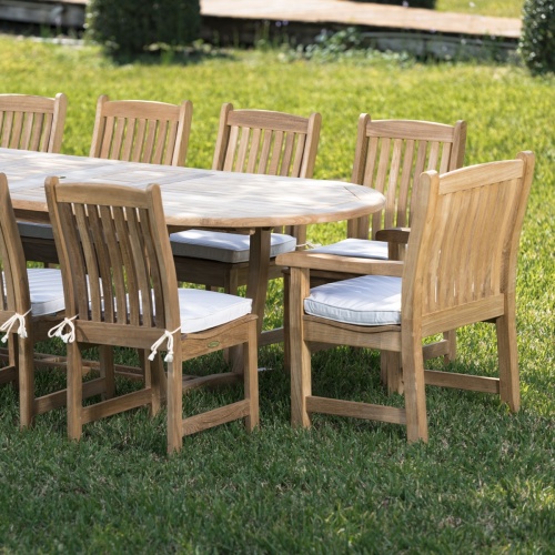70008 Montserrat Veranda eleven piece oval dining set side view showing seat cushions on a grass field 