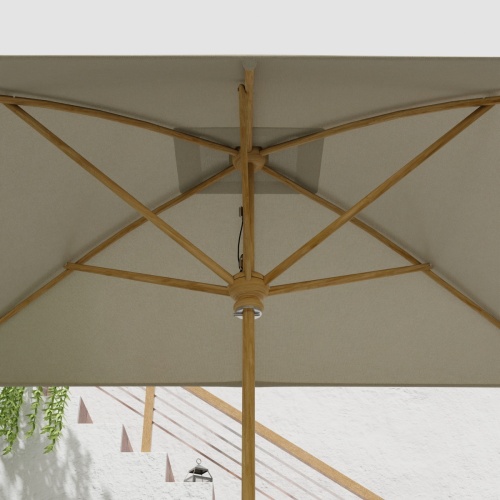 17640F Grand 10 feet Rectangular teak Umbrella with white canvas canopy extended showing the underside of the umbrella canopy and shaft and stretchers with staircase in background