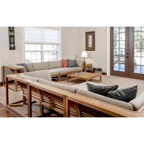 70233 Maya Deep Seating 7 Piece Teak Sofa Set interior angled view on carpet lamp on side table wall mirror galvanized bucket with rolled towels on floor windows and door to outside