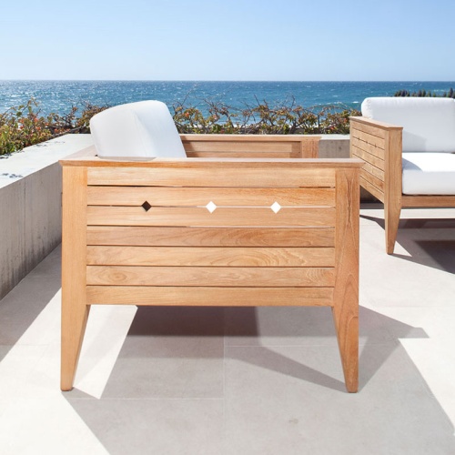 70506 Craftsman teak lounge chair with cushion on outdoor concrete terrace with planter ledge with plants and ocean and blue sky in background