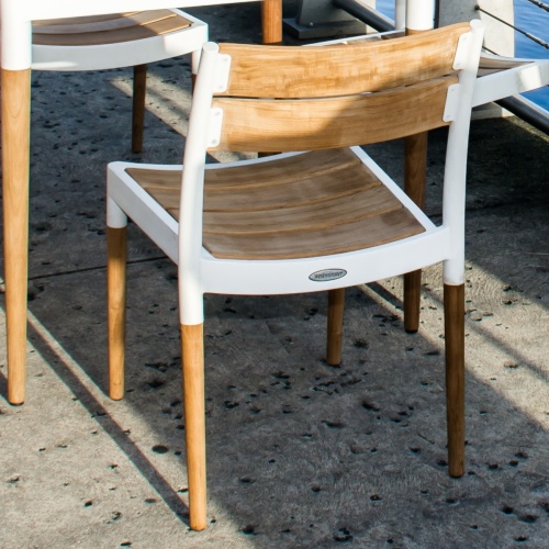 70591 Bloom teak and powder coated aluminum side chair angled rear view on wooden dock with marina background