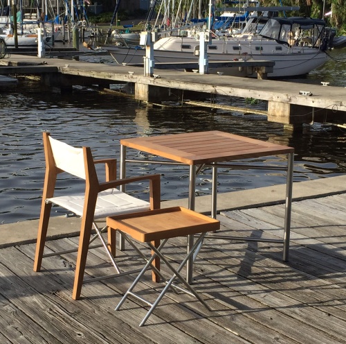 12915RF Refurbished Odyssey Director Chair in marine gloss finish with square table and folding side table on boat dock overlooking the yachts in water