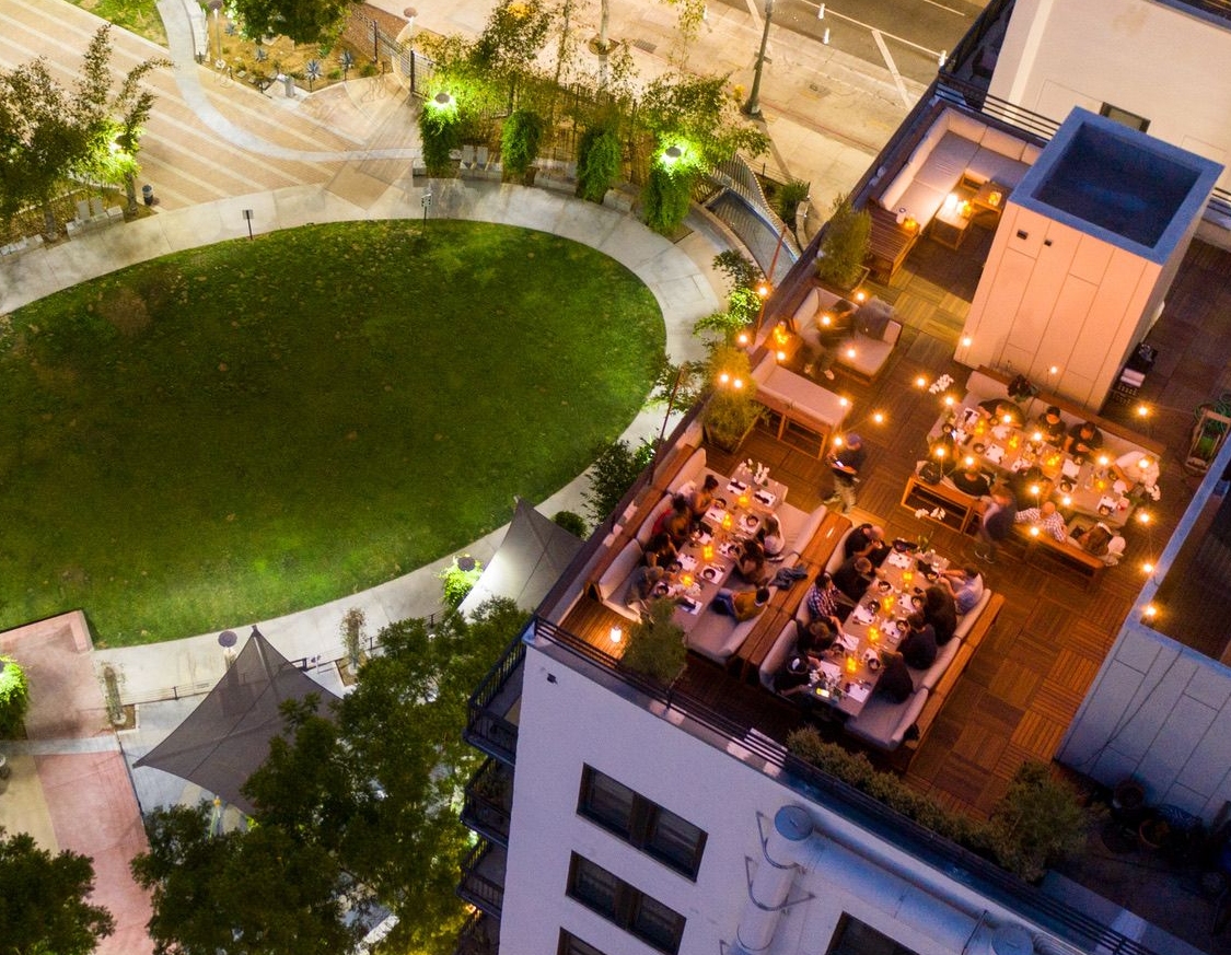 Guests of the Downtown LA Dinner Club enjoying a gourmet meal on their rooftop dining area